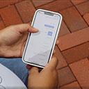 A mobile device with a person using our giving page to give