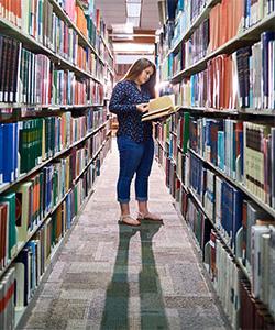 A girl reading a book in the library