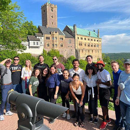 斯泰森大学音乐系学生在欧洲巡演，在城堡前摆姿势